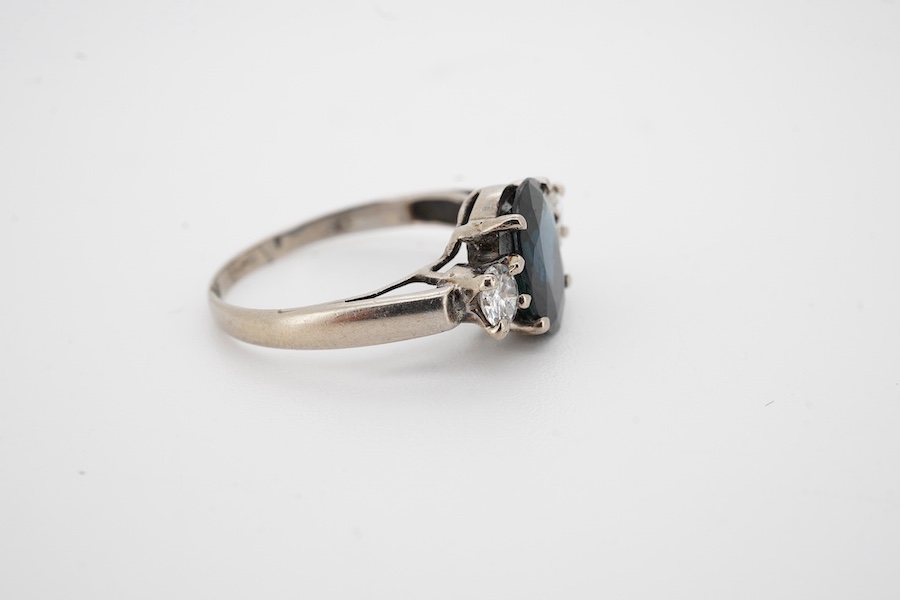 A white metal and single stone oval cut sapphire set ring with two stone diamond set shoulders, size K, gross weight 2.1 grams. Condition - fair to good